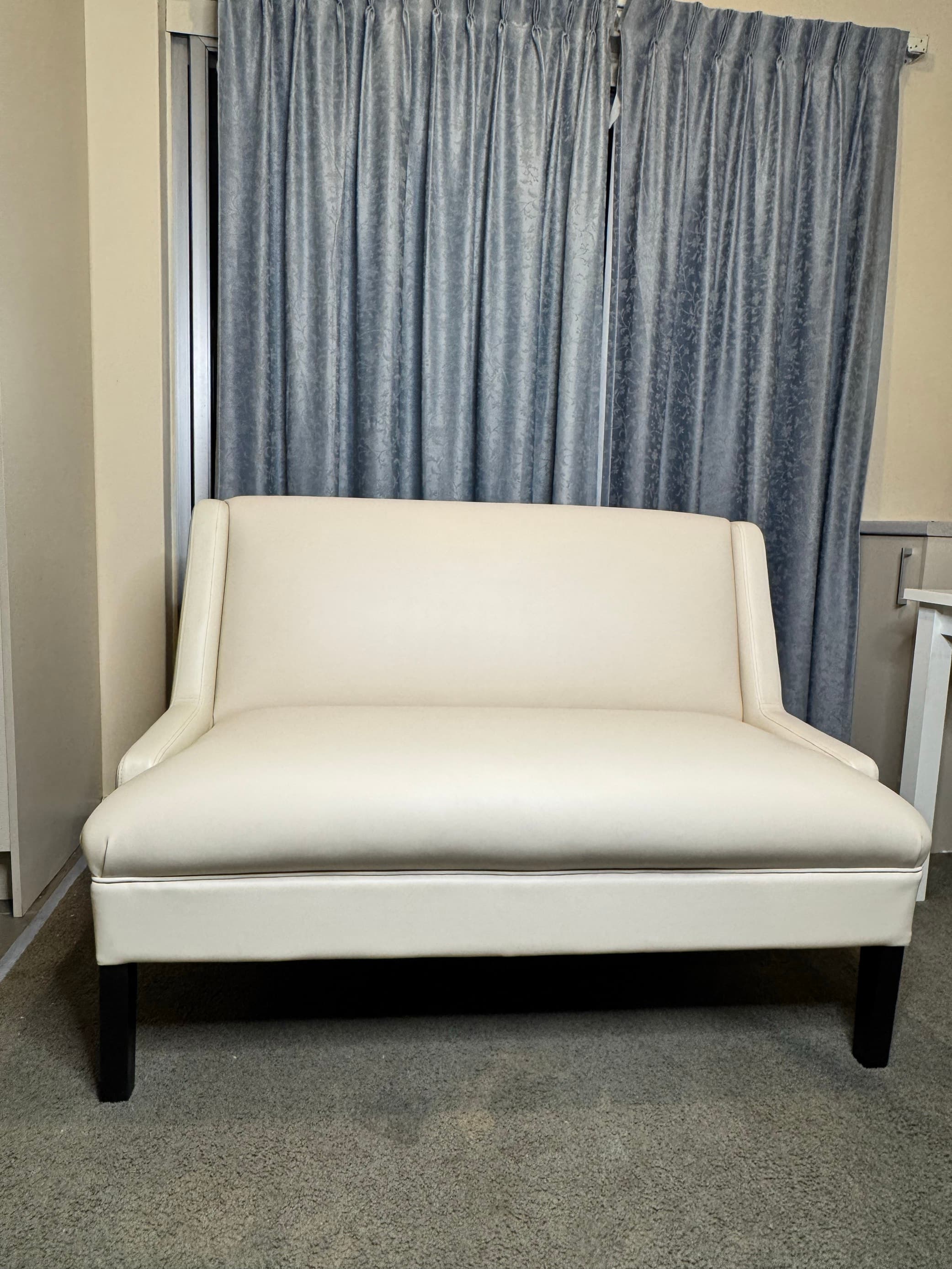 Finished banquette settee upholstered in cream leather